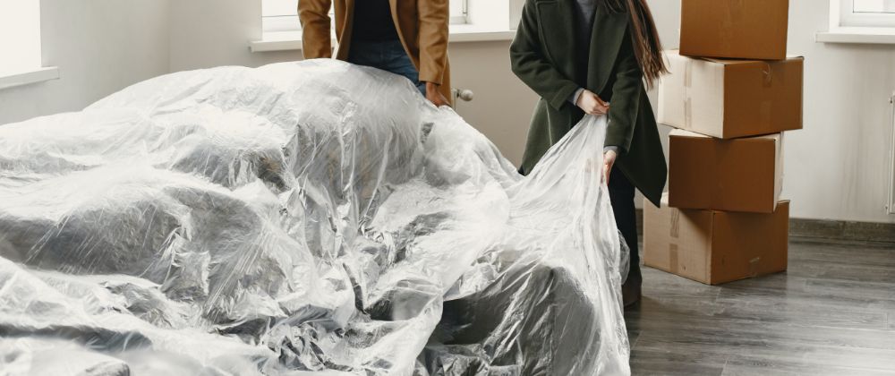 Unoccupied home pictured with protective sheet on furniture and boxes in background