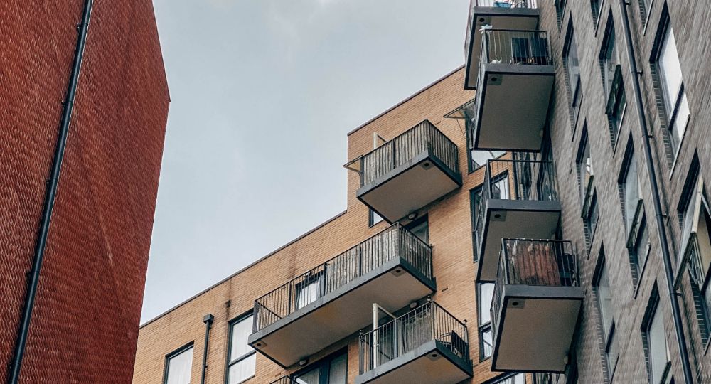 Exterior of modern block of flats with balconies. Shot from below