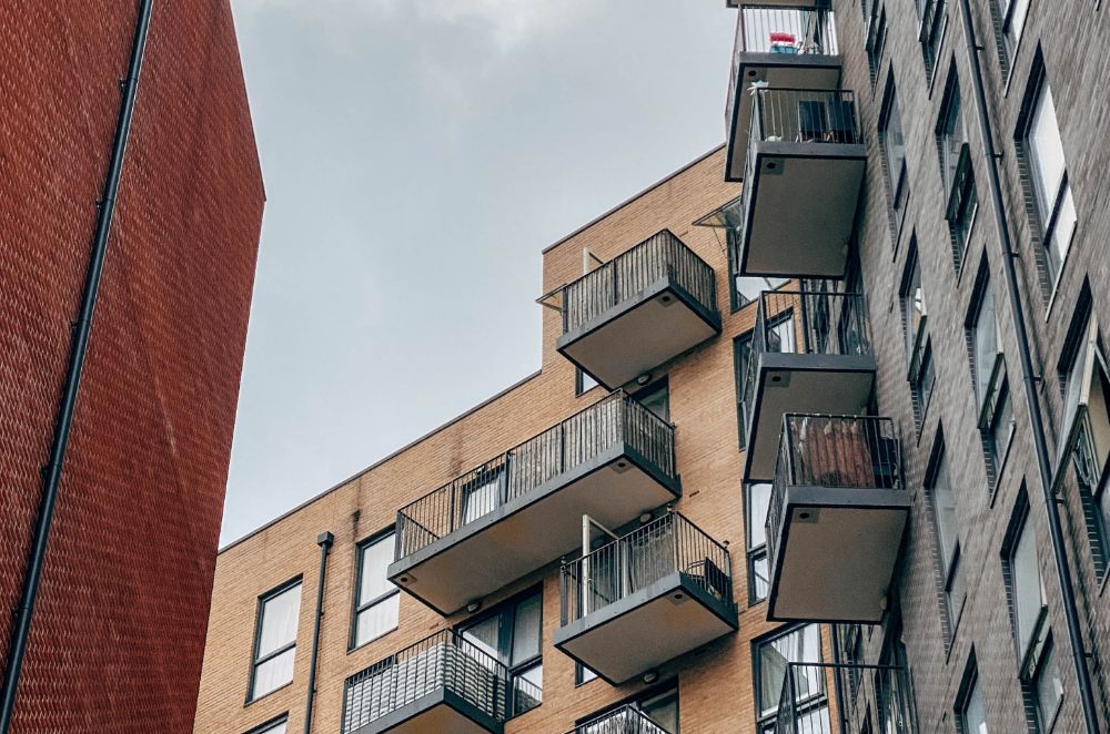 Exterior of modern block of flats with balconies. Shot from below