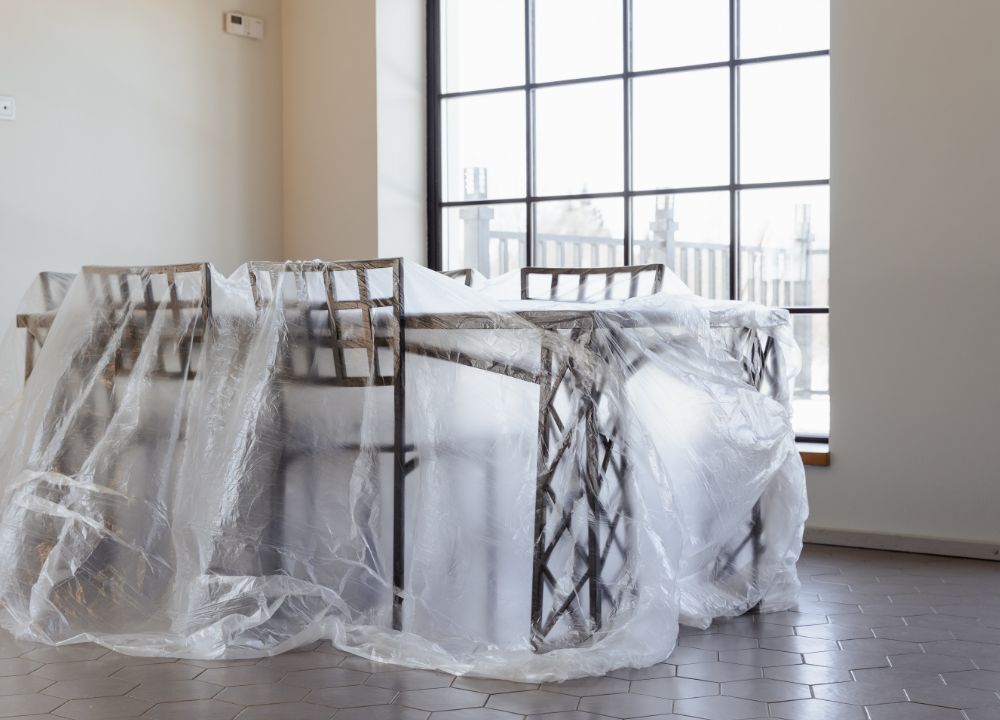 Table and chairs covered with plastic in an unoccupied home