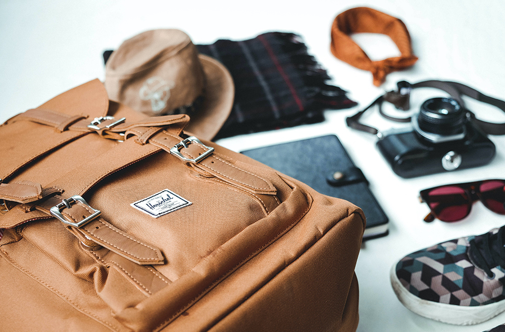 Travel essentials, such as rucksack, camera, sunglasses, journal, hat and more.