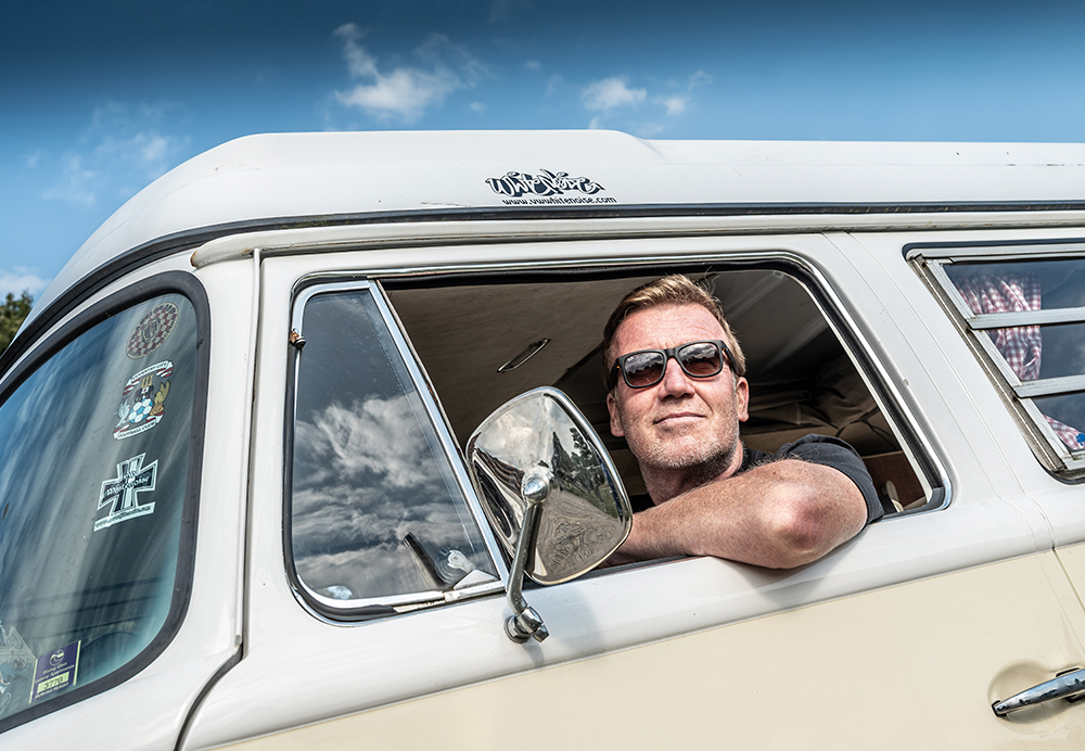 Person looking outside of campervan with arm leaning against side