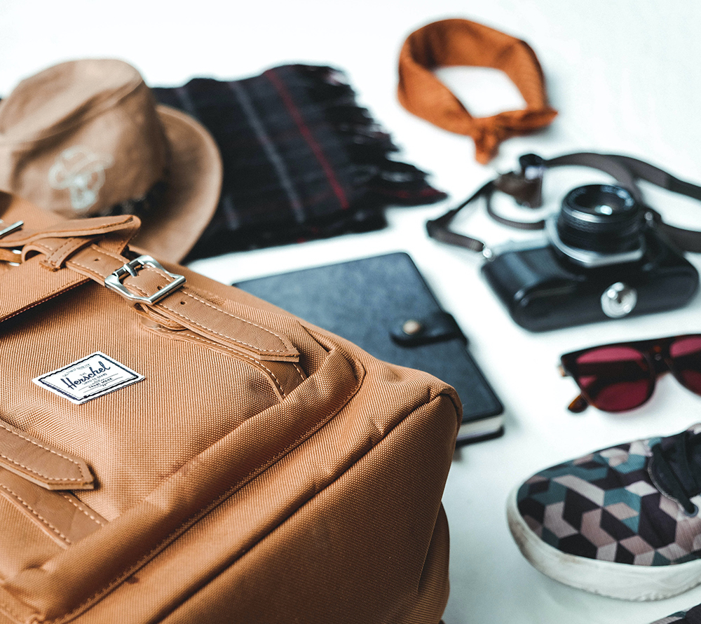 Travel essentials, such as rucksack, camera, sunglasses, journal, hat and more.