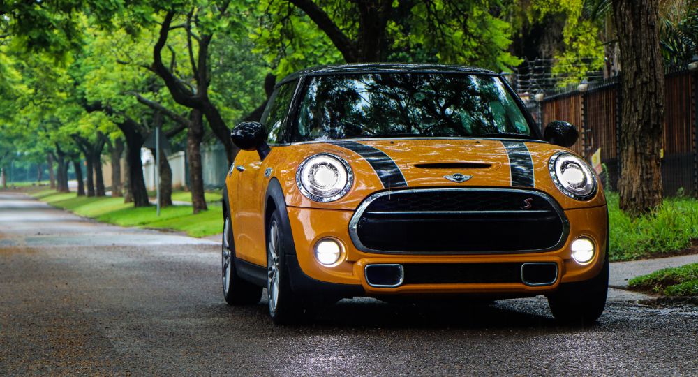 Orange Mini cooper parked on country road