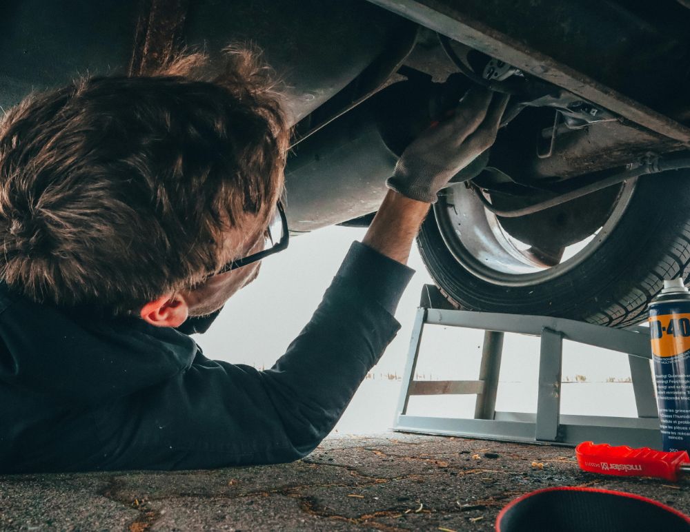 Mechanic fixing underside of a car