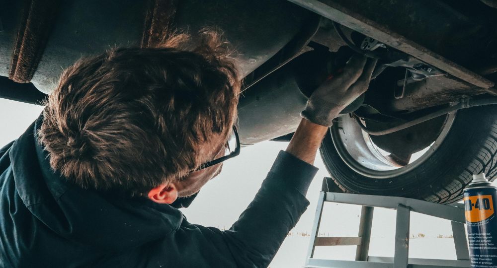 Mechanic fixing underside of a car