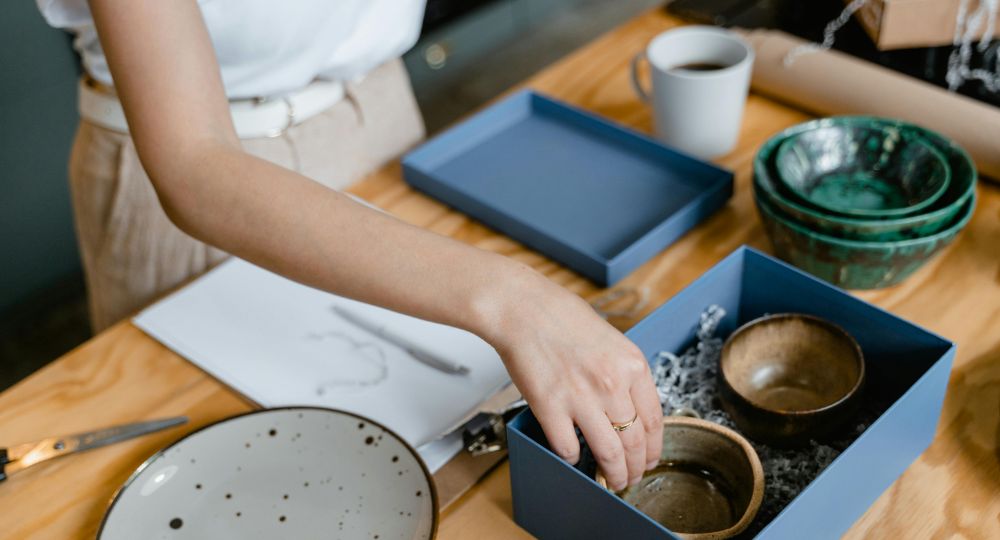 Woman packing pottery into boxes