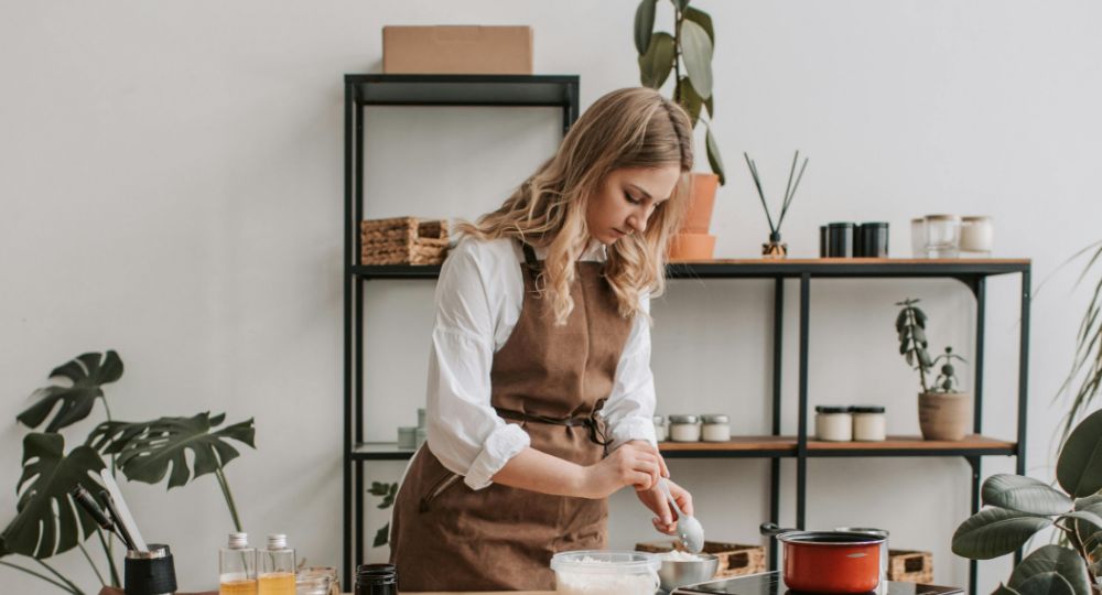 Woman wearing an apron making candles