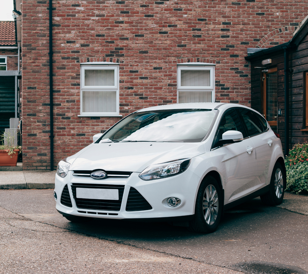 White car parked outside house