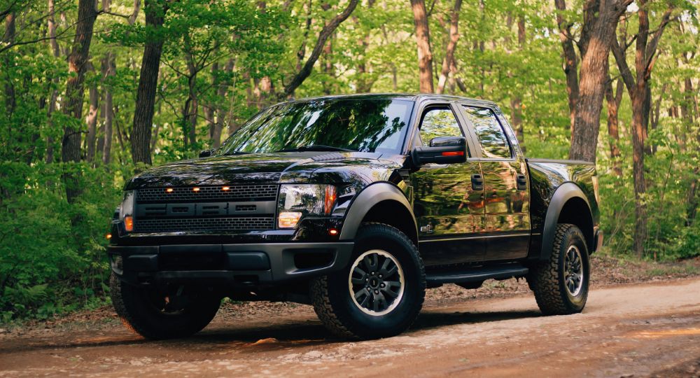 ford pick up truck parked on forest road