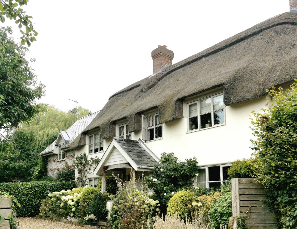 Thatched property with white brick and grey windows