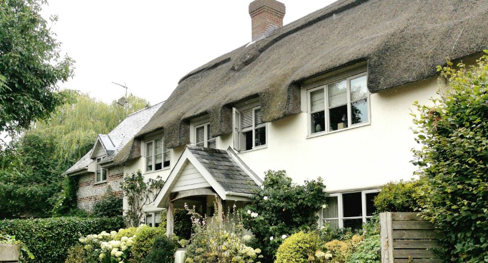 Thatched property with white brick and grey windows