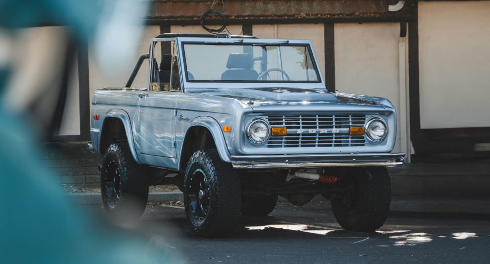 Light blue ford bronco parked in the shade