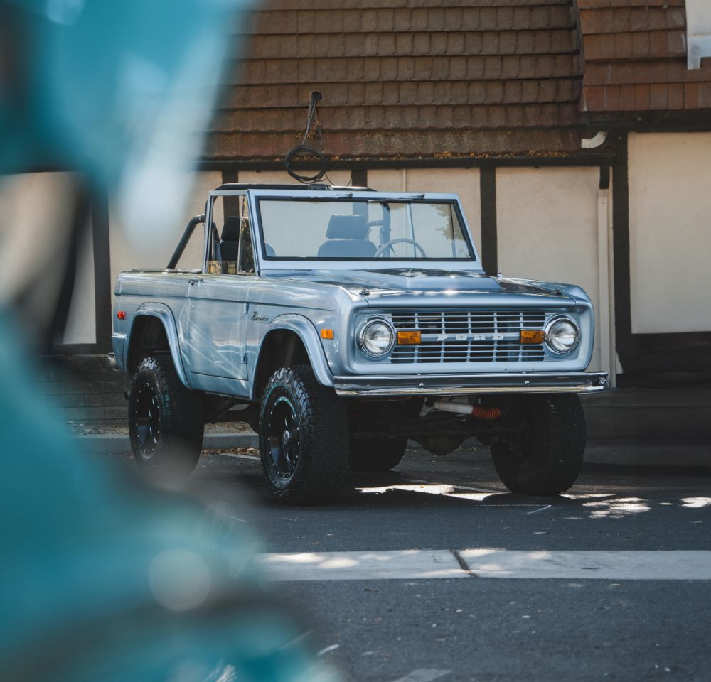 Light blue ford bronco parked in the shade