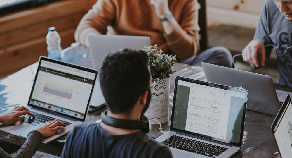 Students with laptops around table