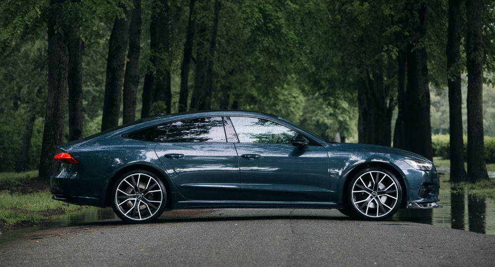 Audi car parked in front of trees