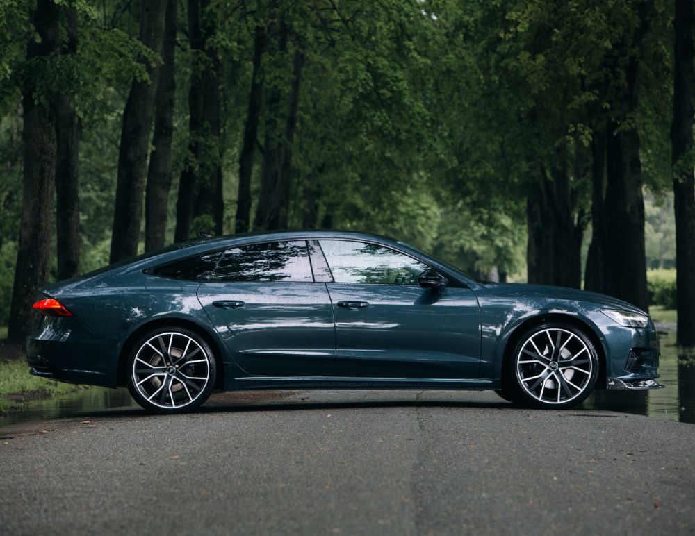 Audi car parked in front of trees