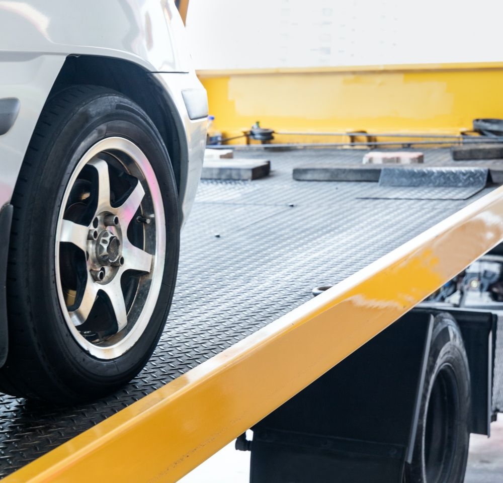 Flux Rescue breakdown picking up silver broken down car on the back of its tow truck