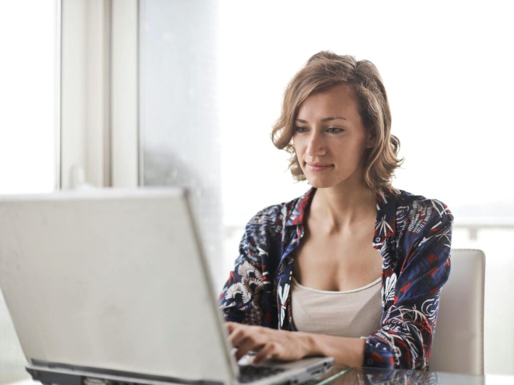 Woman working on laptop and smiling