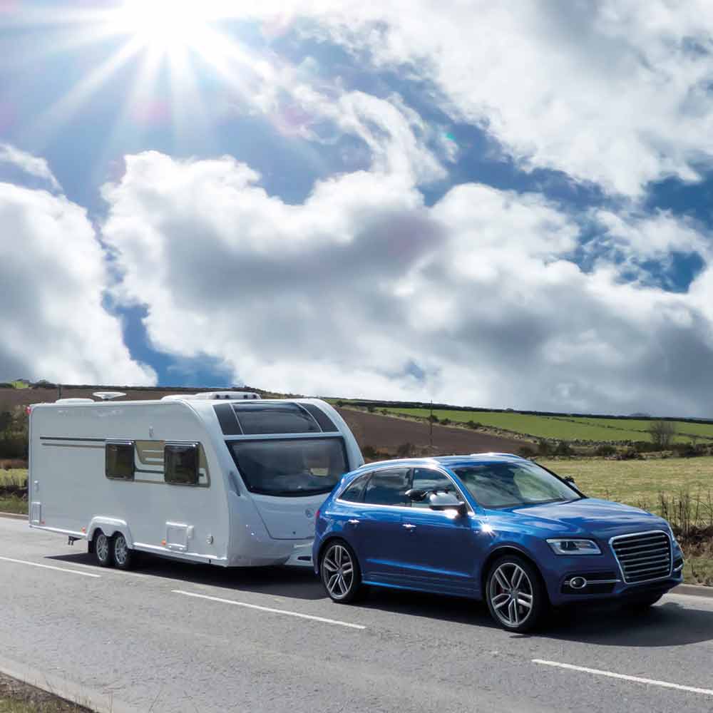 Car towing a caravan on a cloudy day