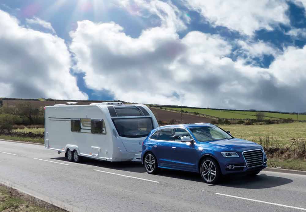 Car towing a caravan on a cloudy day