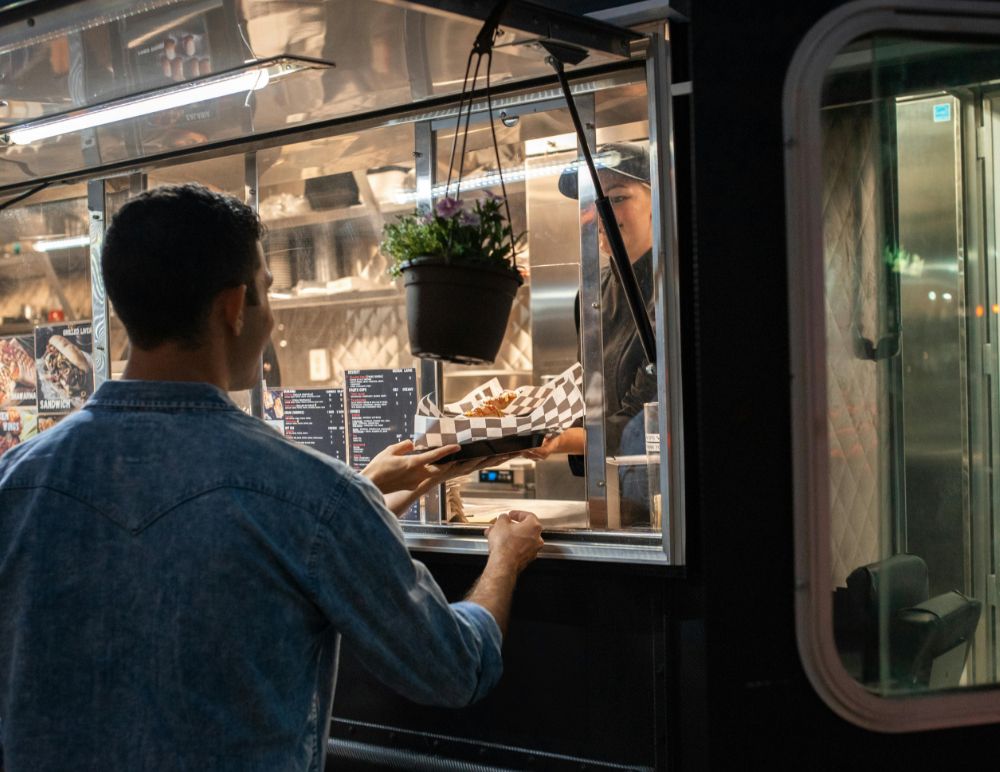 man being served food from a food truck