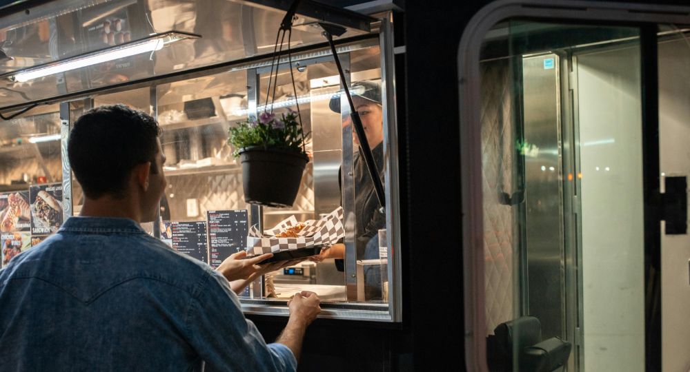 man being served food from a food truck