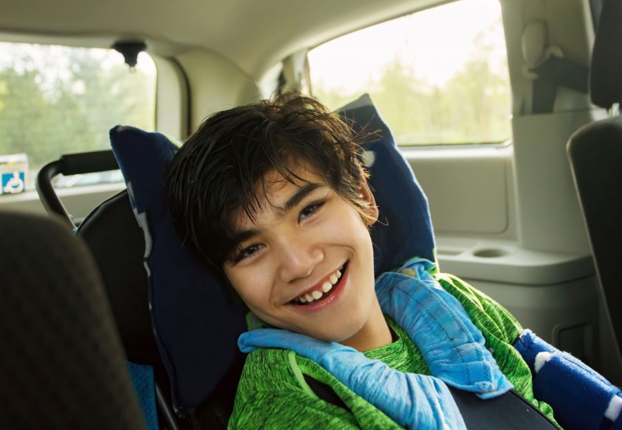 Young boy with a disability sitting in a car