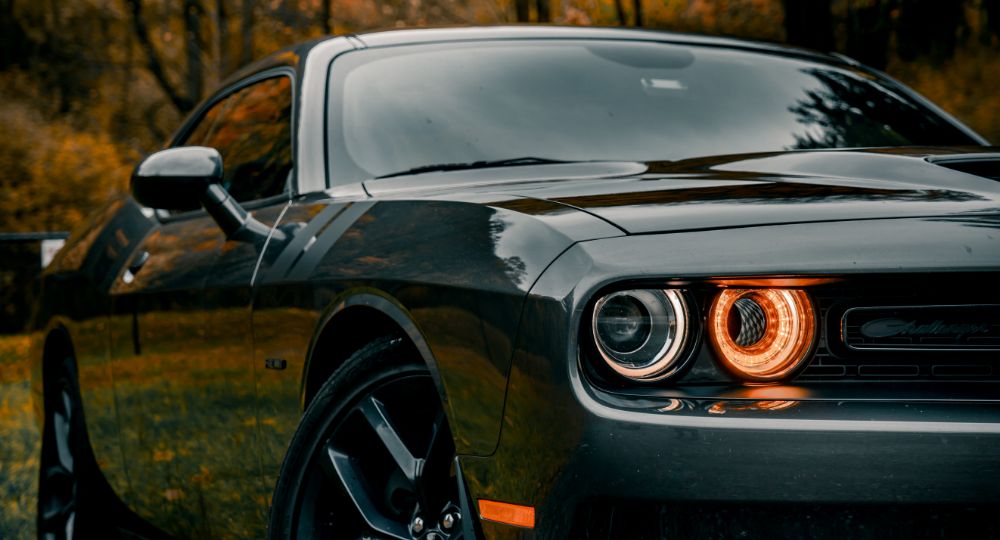 Dodge Challenger parked outside with headlights on