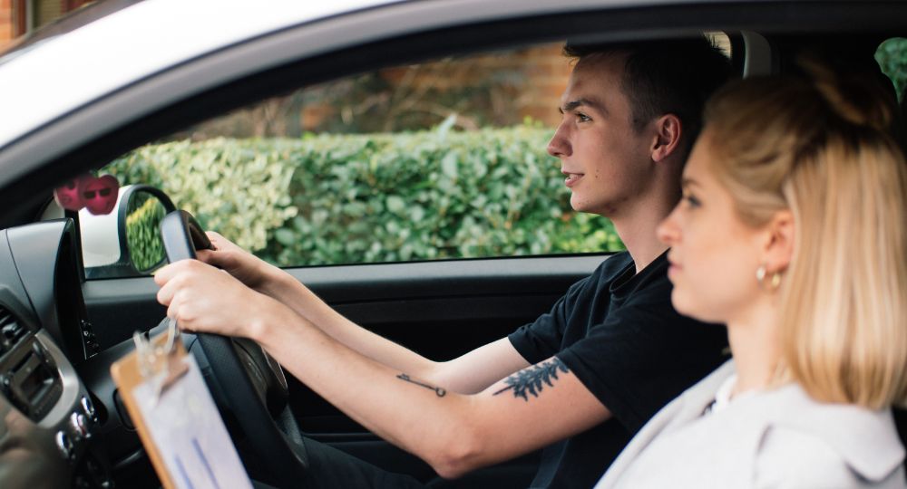 Learner driver in car with hands on steering wheel