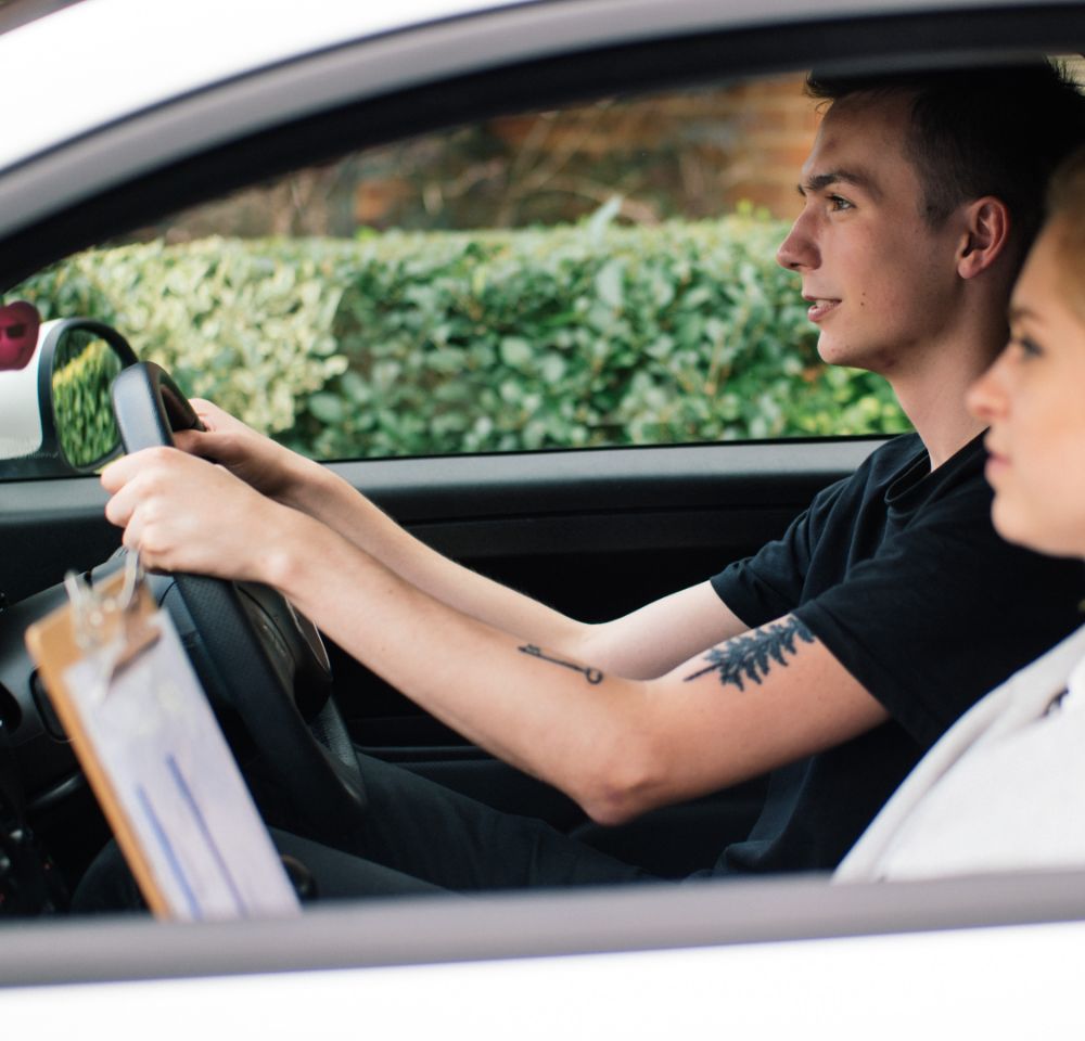 Learner driver in car with hands on steering wheel