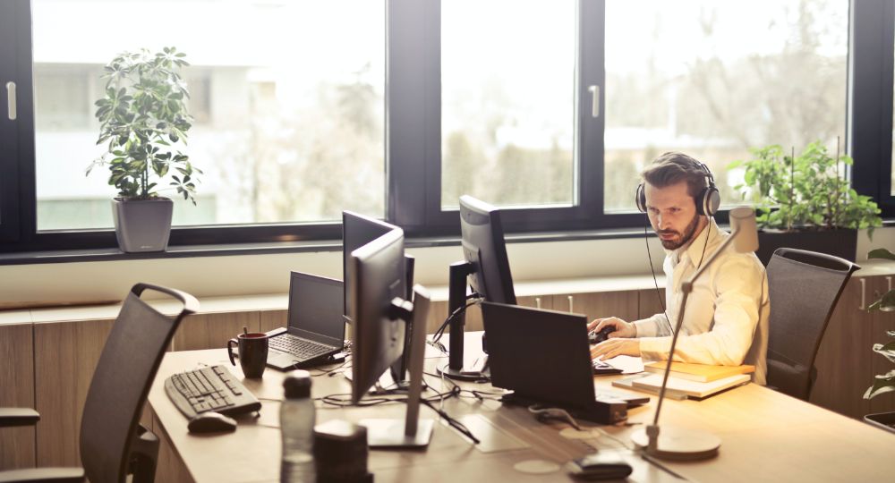 Man sat at desk working on dual screens