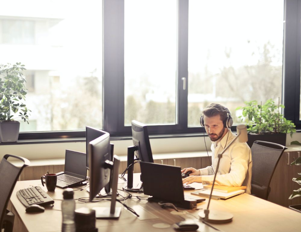 Man sat at desk working on dual screens