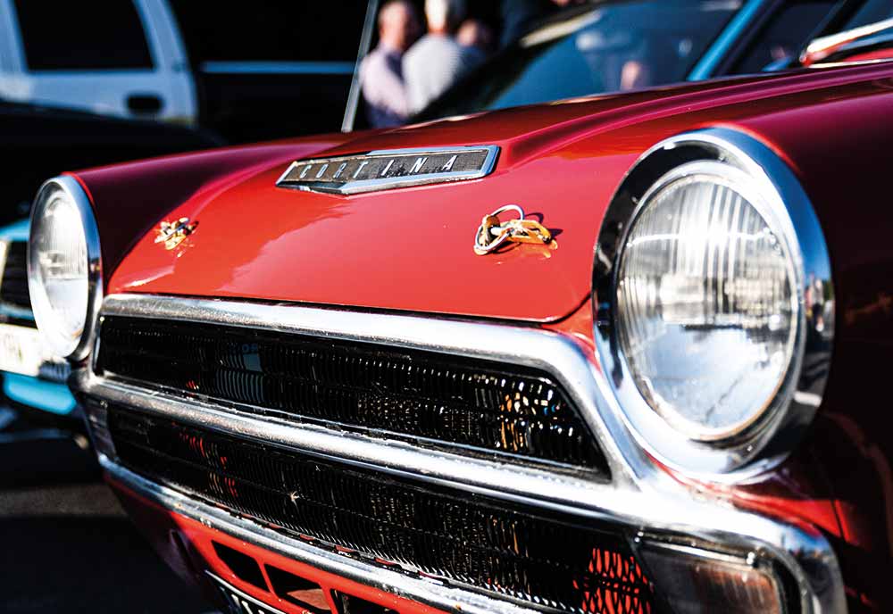 Close-up shot of the front grille of a red Ford Cortina