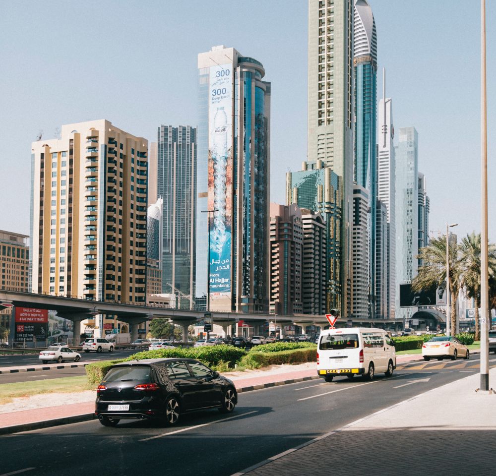 Landscape from a different country with cars on the road in the foreground