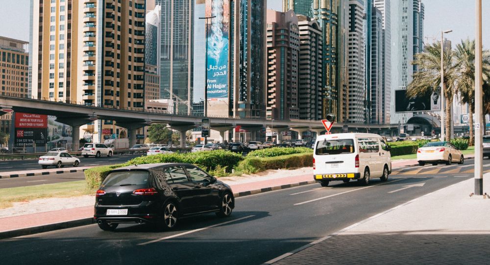 Landscape from a different country with cars on the road in the foreground