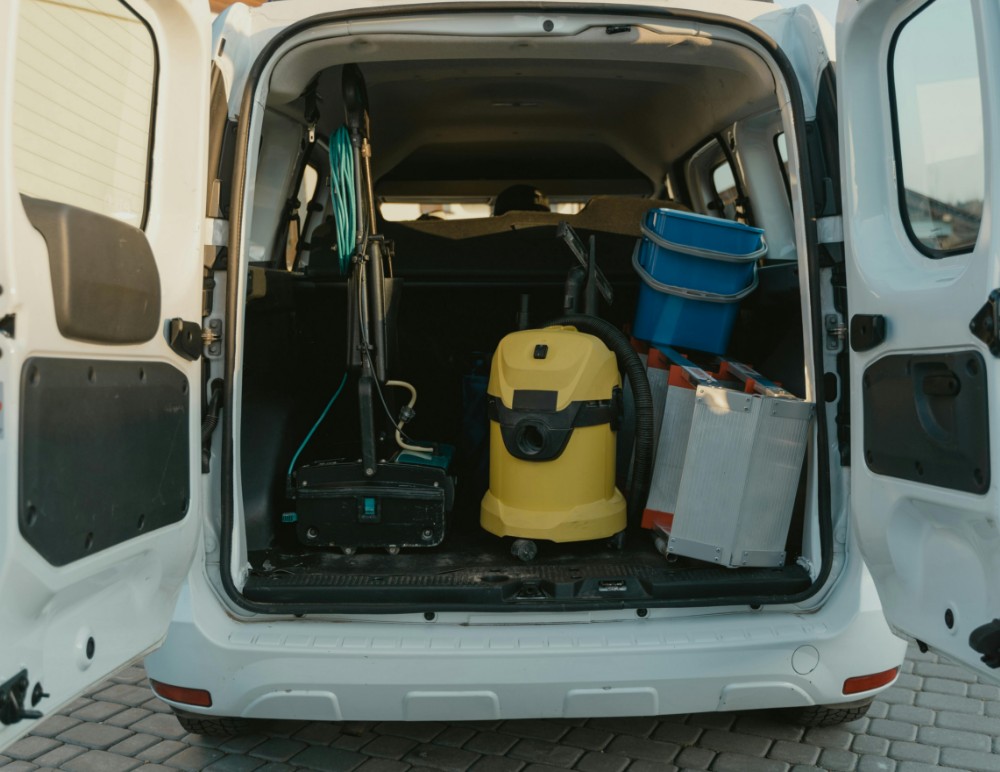 Transit van with back doors open and cleaning equipment inside