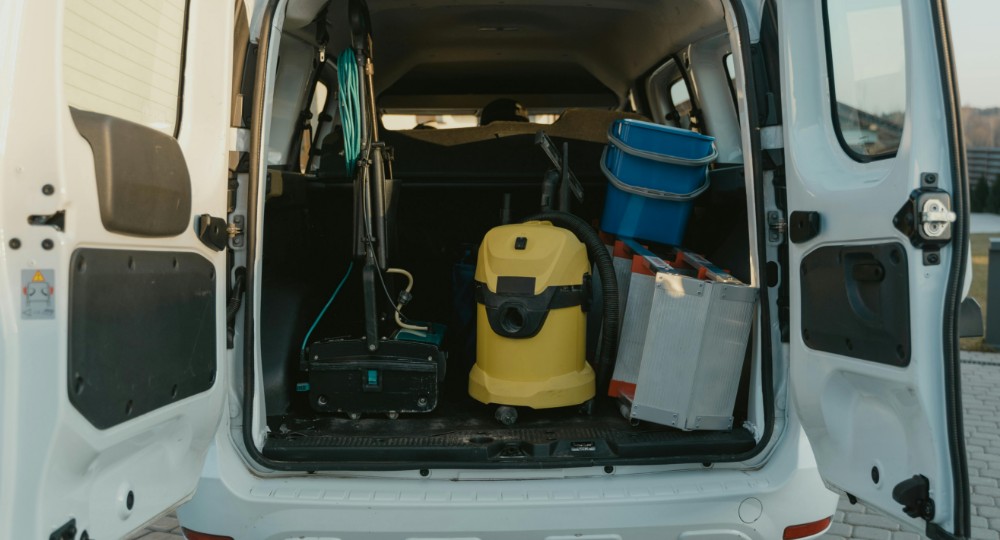 Transit van with back doors open and cleaning equipment inside
