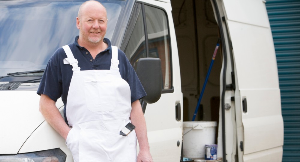 Decorator standing outside his van with painting equipment showing through the open side door