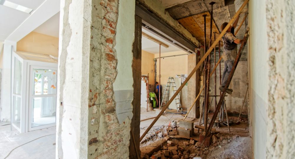 man on ladder renovating room