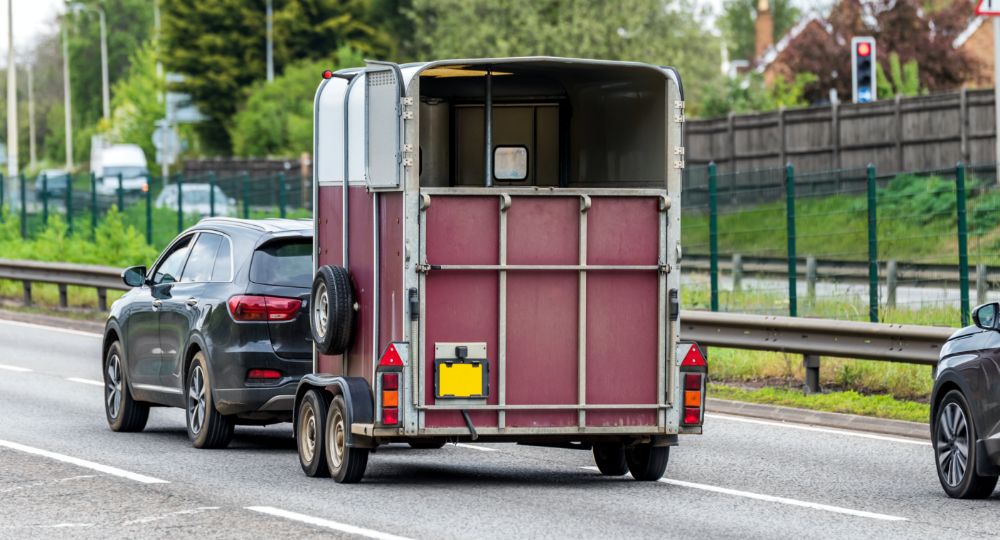 Horse trailer being towed by car