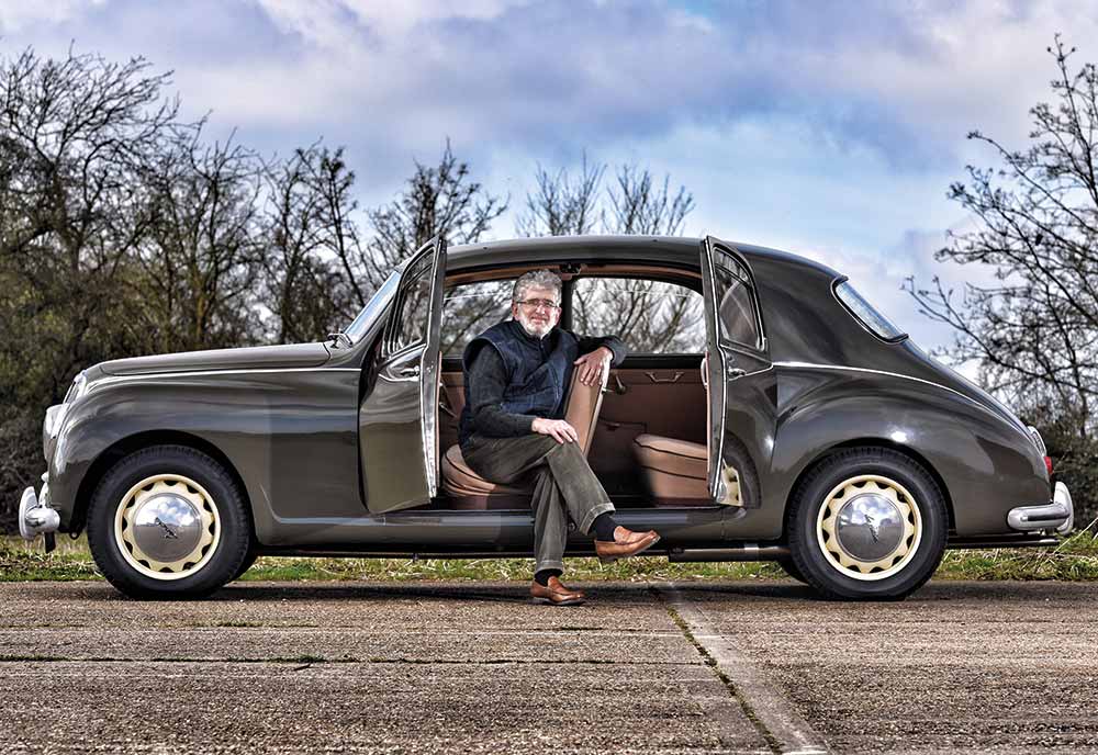 Man sitting in his Lancia with doors open