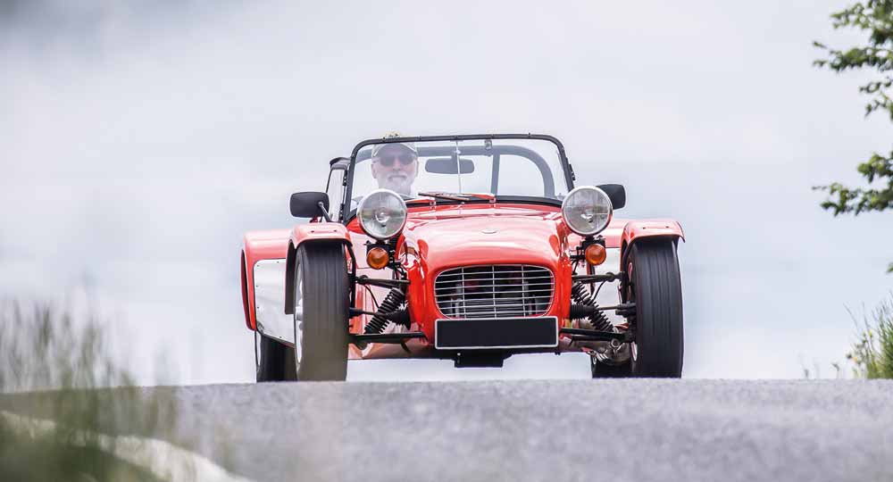 Person in a red Lotus car driving on road