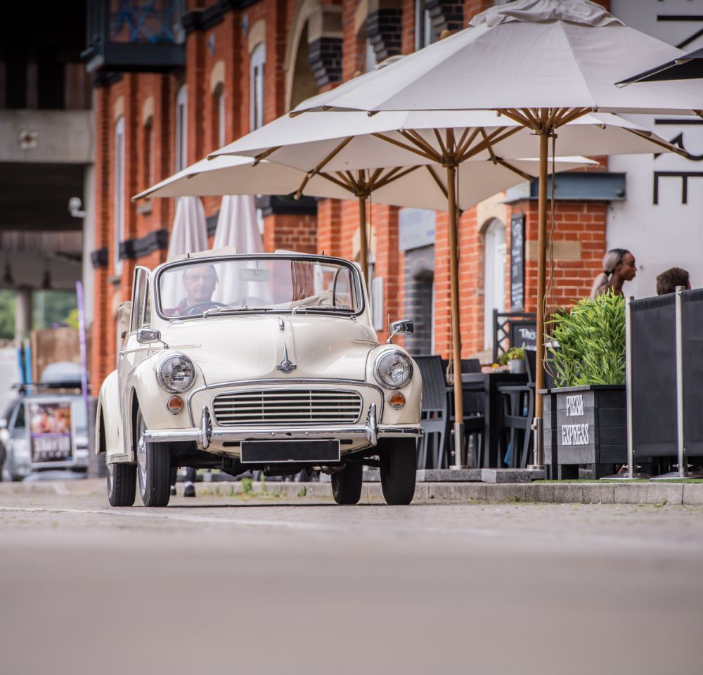 Morris Minor car driving down road