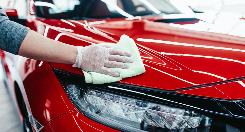 Person wiping down red car