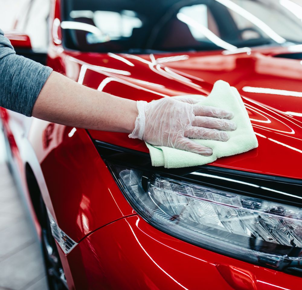 Person wiping down red car