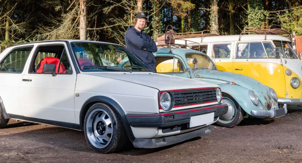 Man standing with his three classic cars