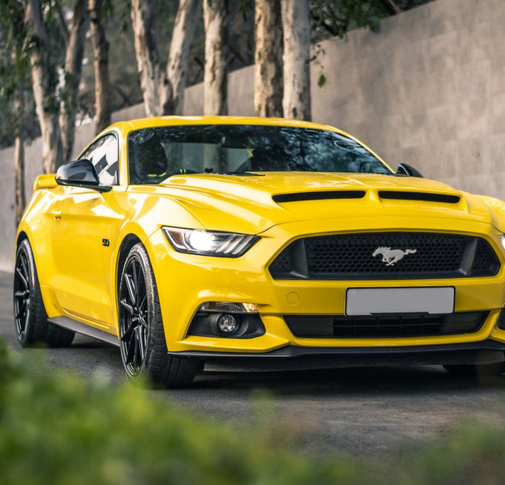 Modern yellow Mustang parked outside