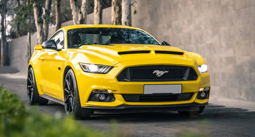 Modern yellow Mustang parked outside