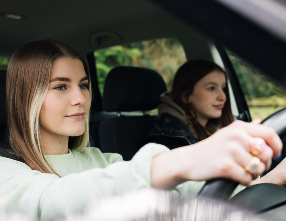 New driver at the wheel of the car with her friend in the passenger seat